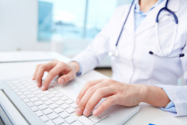 Photo of a woman typing ona a keyboard.