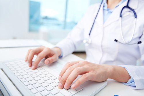 Photo of a woman typing ona a keyboard.